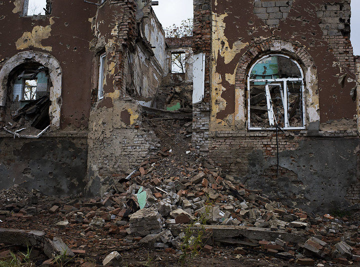 an old red brick building damaged by fighting