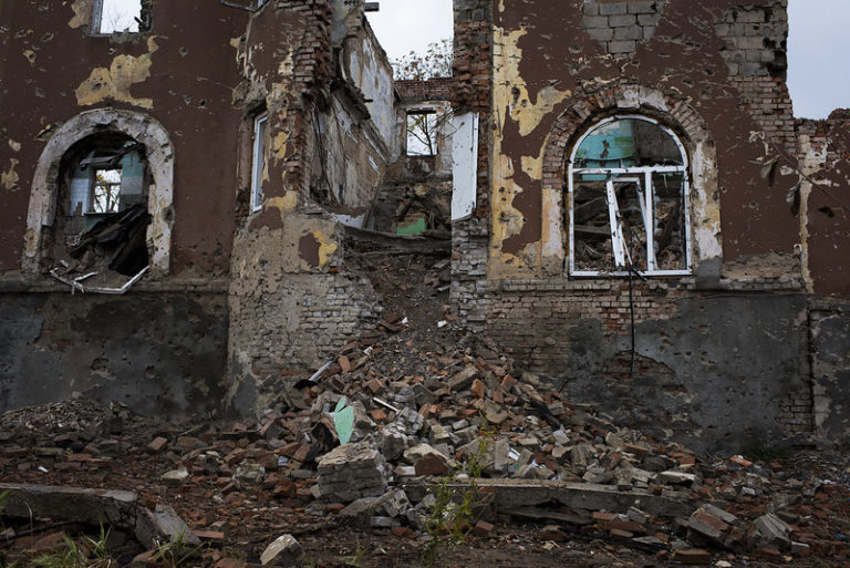 an old red brick building damaged by fighting