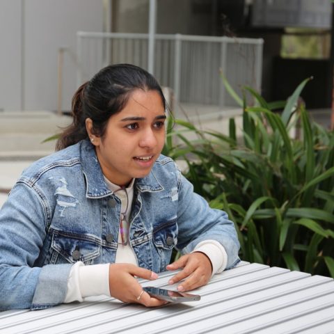 A student sitting at a table engaged in debate