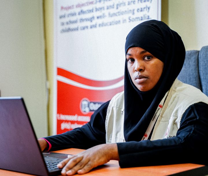 An early childhood educator sits at a computer in an office in Somalia