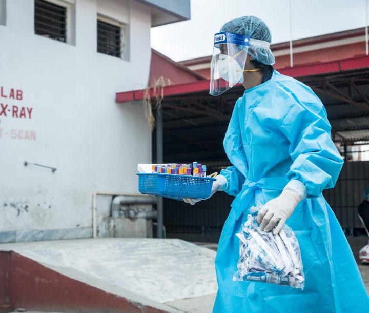 a health worker carries COVID test samples in Nepal