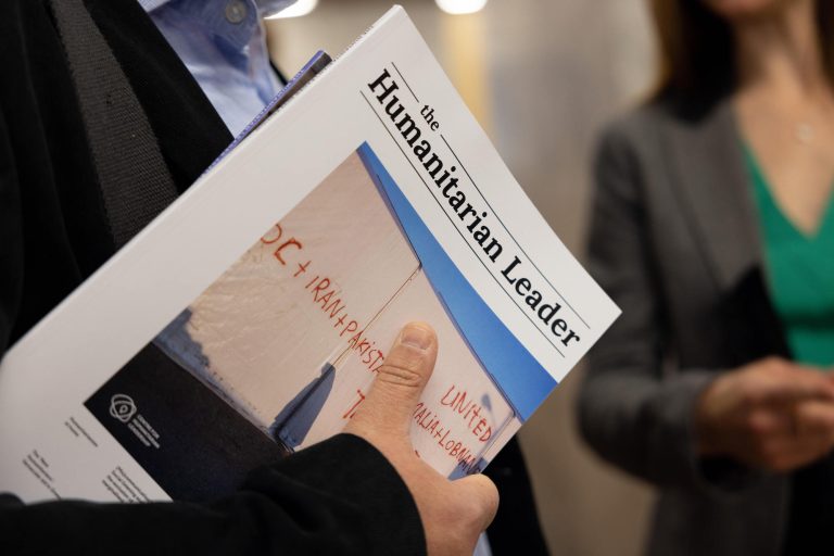 Close up of a person holding a publication with The Humanitarian Leader masthead on the cover